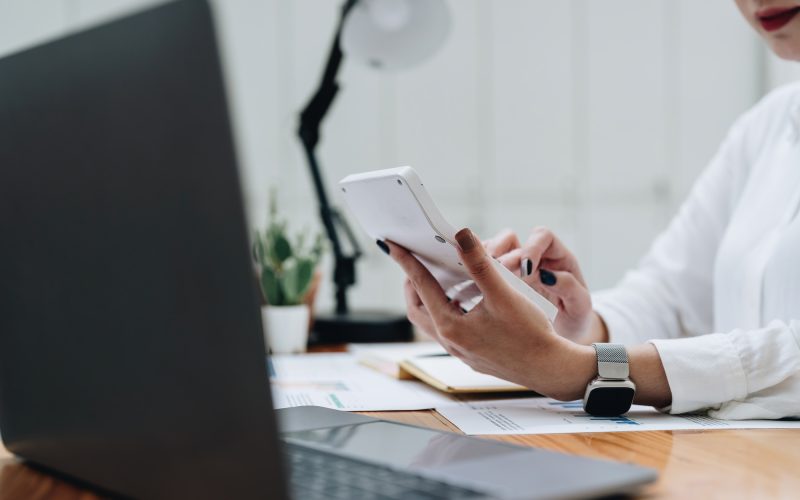 business woman or accountant working on calculator to calculate business data, accountancy document