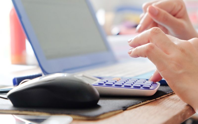close up female hands of accountant with calculator